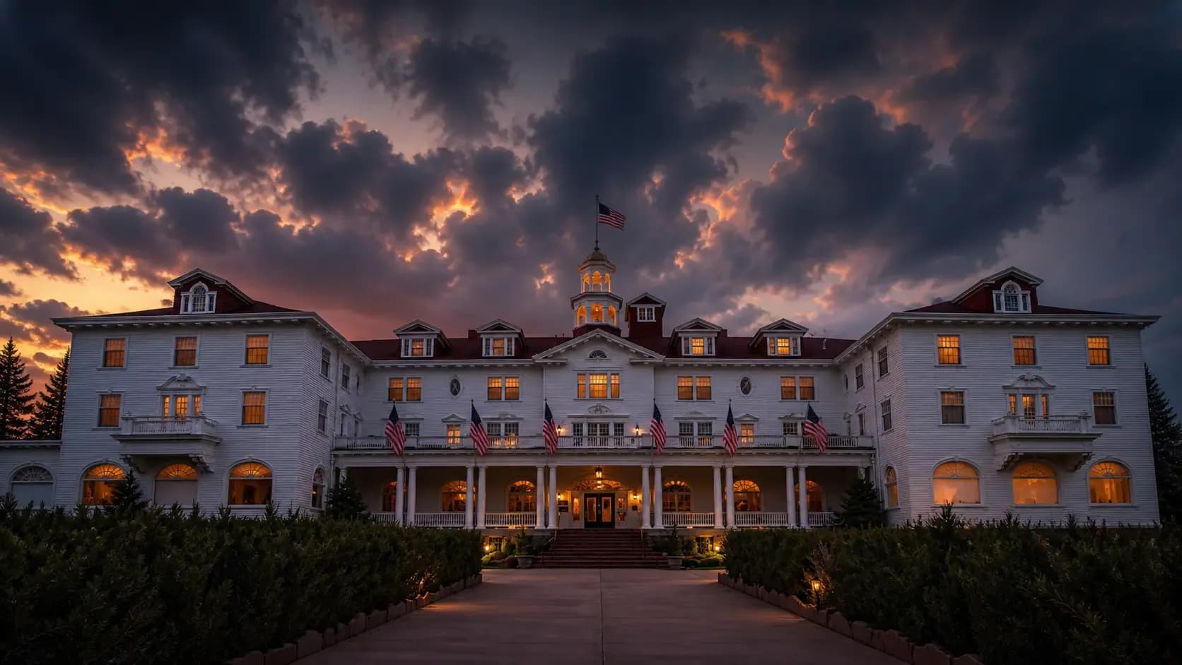 The Stanley Hotel in Estes Park, Colorado at dusk with glowing windows and dramatic clouds