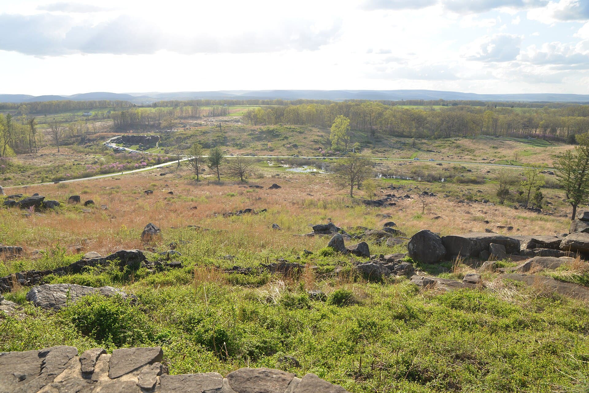 Boulder field of Devil's Den seen from Little Round Top at Gettysburg National Military Park, Pennsylvania, with woodland and open fields beyond