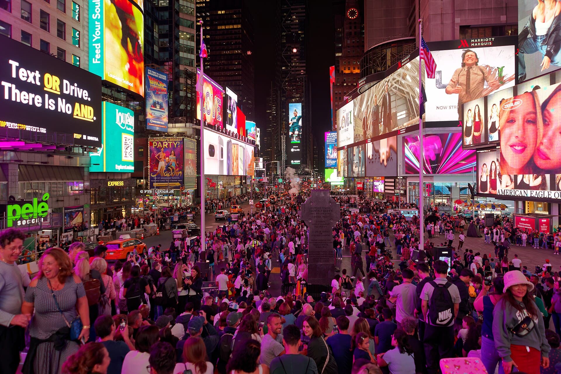 Wide view of Times Square in Manhattan, New York City, with illuminated billboards above the surrounding buildings