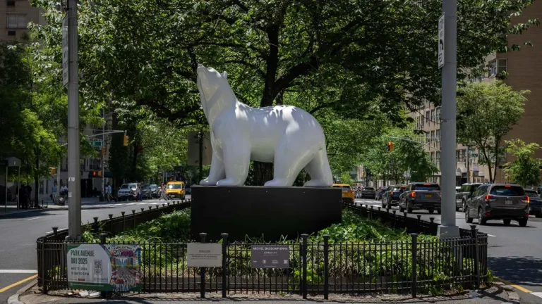 White polar bear sculpture by Michel Bassompierre on Park Avenue in New York City, part of the Fragile Giants exhibit.